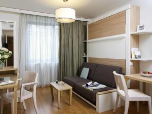 een woonkamer met een bank en een tafel bij Aparthotel Adagio Paris Vincennes in Vincennes +40 foto's