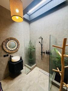 a bathroom with a shower and a sink and a mirror at Villa Santé ubud in Ubud +11 photos