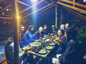 a group of people sitting around a table eating food at Eco Lodge Haputale-Camping Sri lanka in Haputale