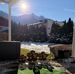 een tuin met uitzicht op een met sneeuw bedekte berg bij Appartement Sammer in Piesendorf