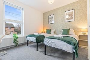 two beds in a room with a window at 3BR Sheffield Home - Contractor Friendly with WiFi in Sheffield