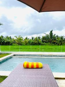 a yellow and orange raft sitting on a mat in a swimming pool at Villa Santé ubud in Ubud