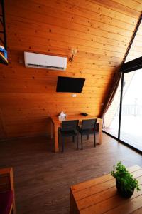 a room with a wooden ceiling with a table and chairs at La Madera Resort in Turbul