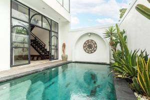 an indoor swimming pool in the backyard of a house at Valentina House in Dalung