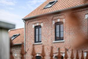 een bakstenen gebouw met ramen en een dak bij Huys van Haeghe in Zoutleeuw +55 foto's