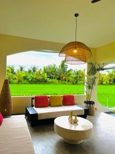 a living room with a couch and a large window at Villa Santé ubud in Ubud