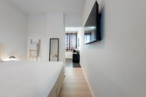 a bedroom with a bed and a tv on a wall at Huys van Haeghe in Zoutleeuw