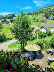 un tavolo con un ombrello e alcuni fiori di Panoramablick Hohenrode a Sasbachwalden