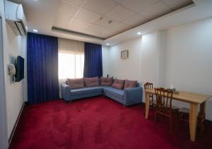 ein Wohnzimmer mit Sofa und Tisch in der Unterkunft Danzha Hotel 1 in Erbil