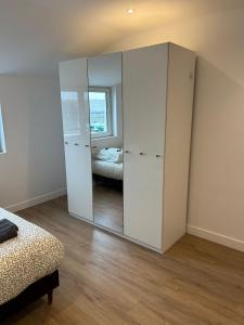 een kamer met een grote spiegel en een slaapkamer bij Le Naval - Confort Familial in Saint-Nazaire