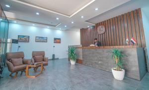 Ein Mann, der an einem Tresen in der Lobby sitzt. in der Unterkunft Danzha Hotel 1 in Erbil