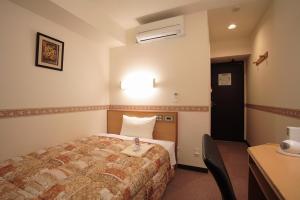 a hotel room with a bed and a desk at Life Inn Katsuta Station West in Hitachinaka