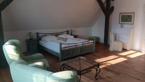 a bedroom with a bed and two chairs and a table at Hotel & Spa Wasserschloss Westerburg in Westerburg