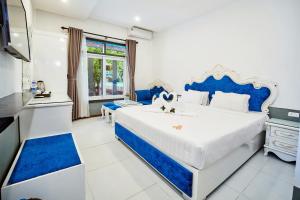 een blauwe en witte slaapkamer met een groot bed bij Nostalgia Hotel and Spa in Hội An +69 foto's