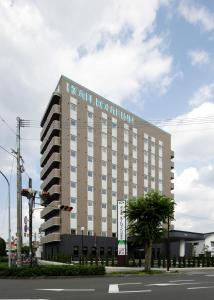 a hotel with a sign on the side of a building at Hotel Route-Inn Hita-Ekimae in Hita