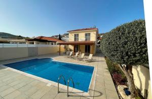 a swimming pool in front of a house at Villa Rossa in Pissouri