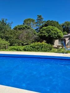 een blauw zwembad voor een huis bij Oasis in Villa Anizacate