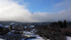 een berg in de wolken boven een stad met sneeuw bij Mountainview Apartment Ski, Spa & Thermal in Bansko