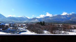 een uitzicht op een besneeuwde bergketen met bergen op de achtergrond bij Mountainview Apartment Ski, Spa & Thermal in Bansko