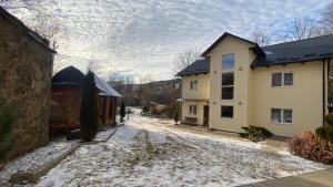 een huis met sneeuw op de grond naast een gebouw bij Edelweiss in Lazeshchyna