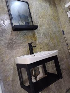 ein Badezimmer mit einem weißen Waschbecken und einem Spiegel in der Unterkunft BP family room 4 in Ko Mak