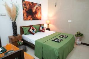 a bedroom with a bed with a green comforter at Singha Residences Thalawathugoda in Bokundara