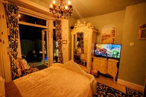 a bedroom with a bed and a tv and a mirror at The Mirador Boutique Town House in Swansea