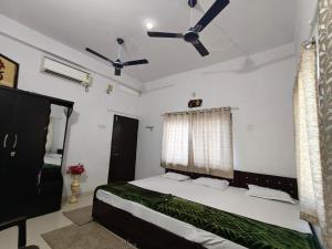 a bedroom with a bed and a ceiling fan at NANDI Home Stay in Ujjain