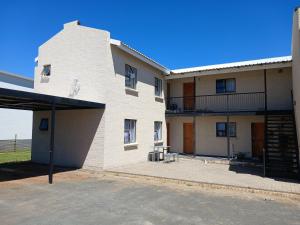 a white building with a parking lot in front of it at Karoo-Hart in Orania