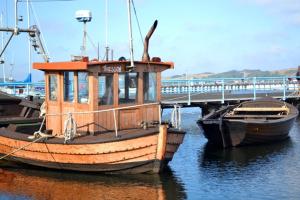 two boats are docked in the water near a bridge at Ferienwohnung Seestern Suite im Haus Sonnensegler in Thiessow