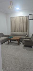 een woonkamer met banken en een salontafel bij صدي للشقق المخدومة in Quai