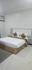 een slaapkamer met een groot bed met kussens erop bij صدي للشقق المخدومة in Quai