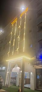 een hoog gebouw met 's nachts verlichting bij صدي للشقق المخدومة in Quai