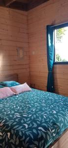 een slaapkamer met een bed en een raam bij Les chalets de ravine citrons in Entre-Deux