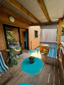 een terras met een blauwe tafel en stoelen bij Les chalets de ravine citrons in Entre-Deux