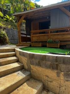 een huis met een gazon en een trap ervoor bij Les chalets de ravine citrons in Entre-Deux +1 foto