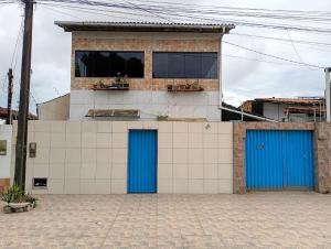 a building with two blue doors on a building at Sol e Praia in Prado