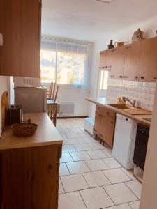 een keuken met witte apparatuur en een tegelvloer bij 200m de la plage ,3mn du port à 50m du centre ville in Carry-le-Rouet