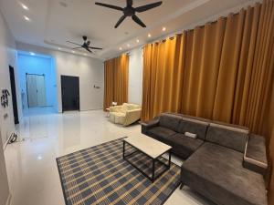 ein Wohnzimmer mit Sofa und Tisch in der Unterkunft HomestayDino in Kuala Terengganu