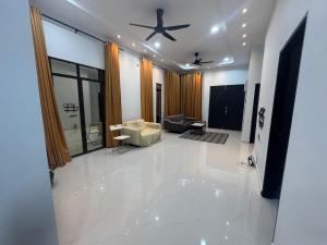ein großes Wohnzimmer mit einem Deckenventilator in der Unterkunft HomestayDino in Kuala Terengganu