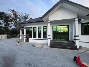 ein kleines Kind vor einem Haus in der Unterkunft HomestayDino in Kuala Terengganu