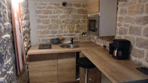 een keuken met een wastafel en een stenen muur bij Luxury Suite Lilas in Dijon