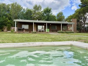 una grande piscina d'acqua davanti a una casa di Casa Los Talas La Cumbre Argentina a La Cumbre
