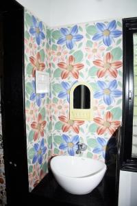 a bathroom with a sink and flowers on the wall at Daneshwari Bhakt Niwas in Akalkot