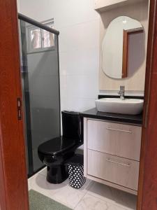 a bathroom with a black toilet and a sink at Refúgio da Lagoa in Florianópolis +20 photos