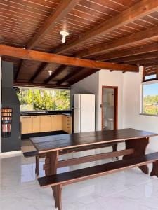 a large wooden table in a room with a kitchen at Refúgio da Lagoa in Florianópolis