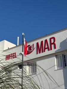 ein Schild für ein Hotel mit einem roten Schild an einem Gebäude in der Unterkunft Hotel Che Mar in Necochea