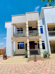 a large white house with balconies and a patio at Lucia Homes & Stays in Dodoma