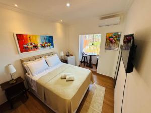 een slaapkamer met een bed en een televisie. bij Residence Pipa Beach in Pipa