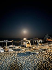 a beach with umbrellas and chairs and the ocean at Apágkio Filoxenia in Archangelos +157 photos